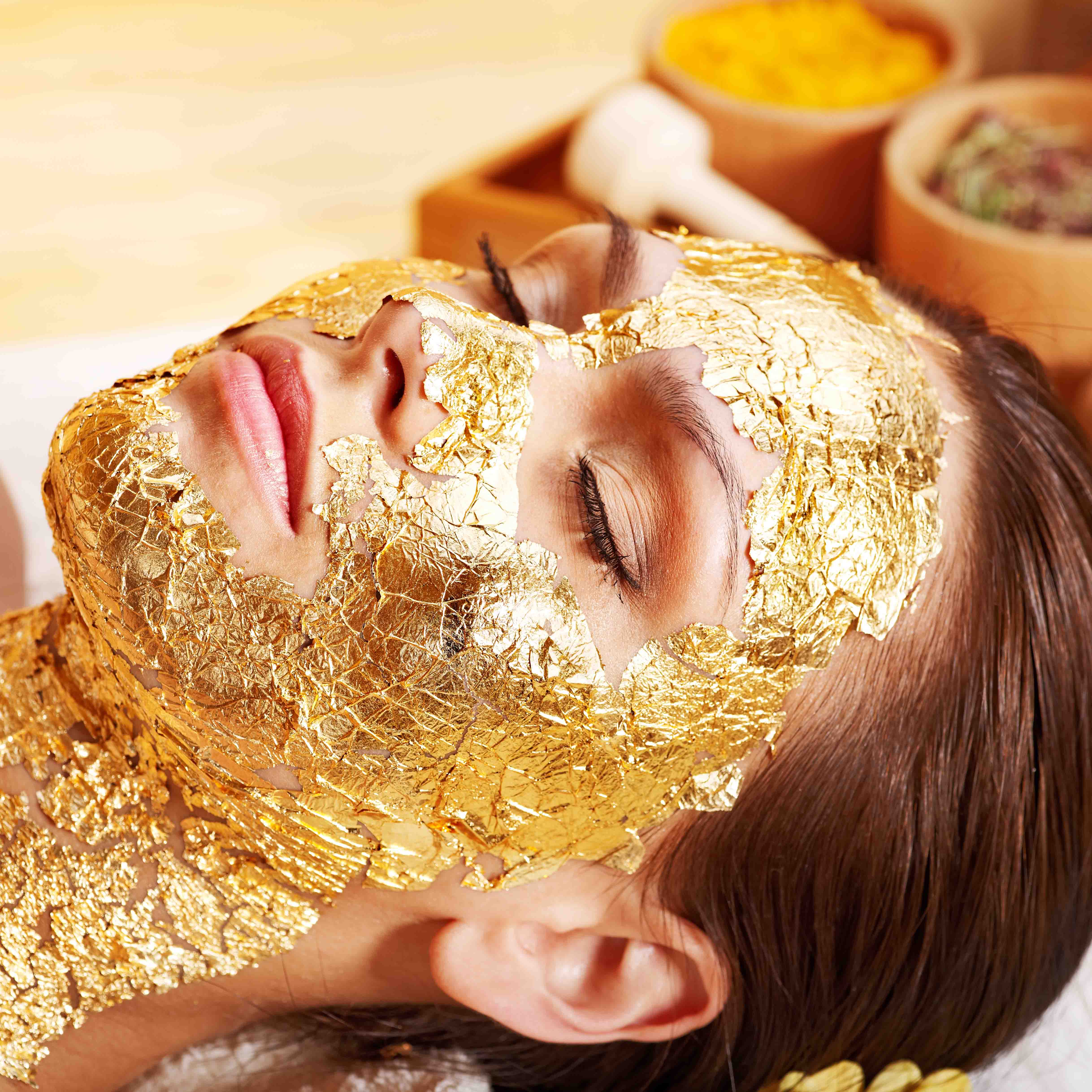 Woman,Getting,Gold,Facial,Mask.